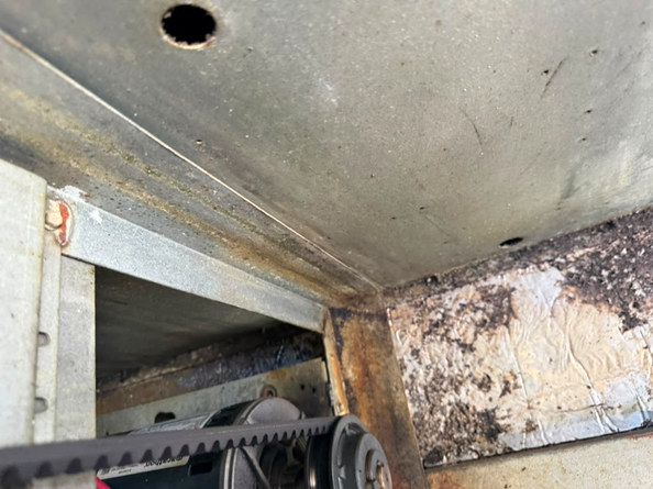 A close-up view of the tight, restrictive ductwork transition inside the curb area.