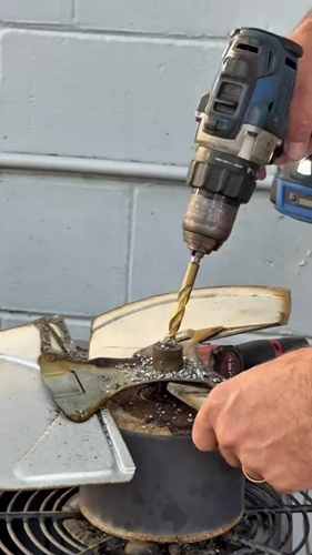 Drilling out the stuck hub to free the seized fan blade without damaging it.