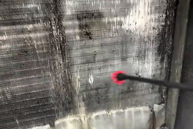 Our technician cleaning the coil with a sprayer and approved coil cleaner.